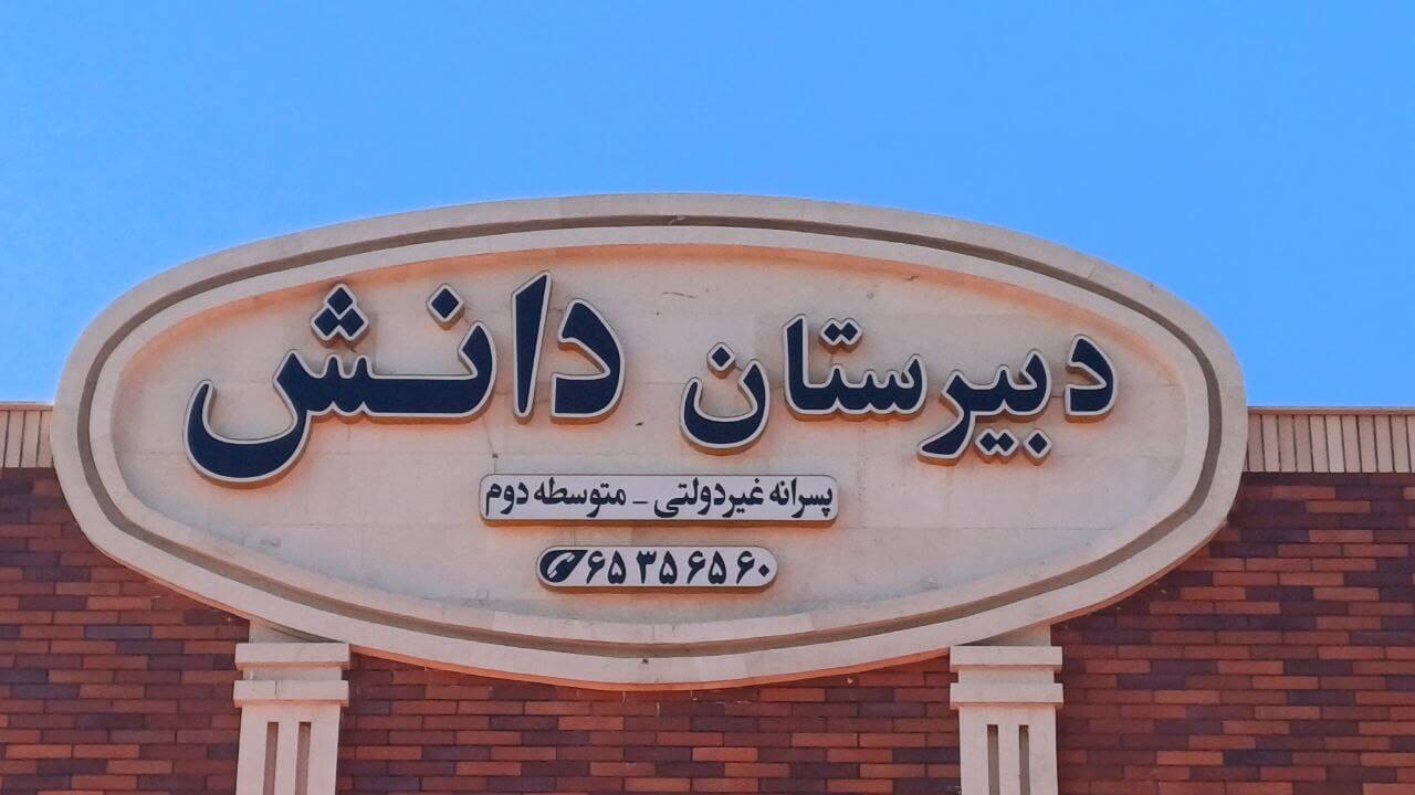 تابلوی دبیرستان دانش روی نمای آجری ساختمان