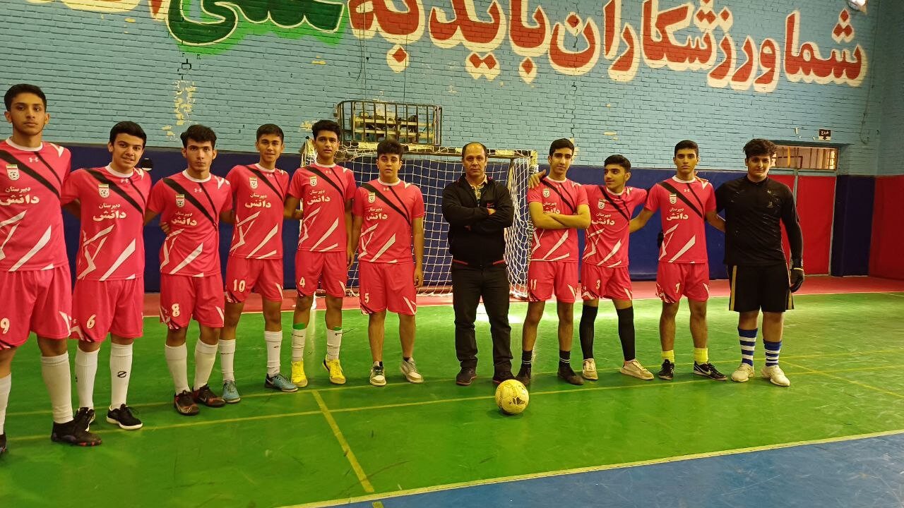 تیم فوتسال دانش کنار مربی در سالن ورزشی